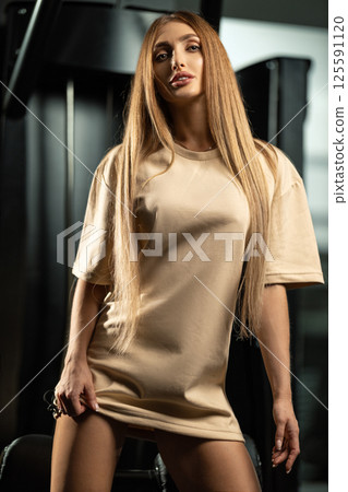 confident model stands in modern gym environment wearing casual athletic outfit. atmosphere highlights wellness and fitness culture emphasizing healthy lifestyle. confident model stands in modern gym environment wearing casual athletic outfit. atmosphere highlights wellness and fitness culture emphasizing healthy lifestyle. 125591120
