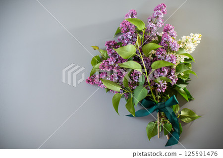 Bouquet of white and purple lilacs on a gray background 125591476