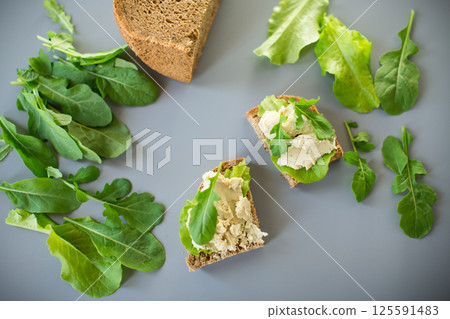 Homemade rye bread with herring paste and arugula 125591483