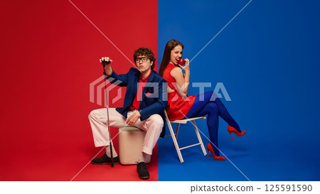 Couple smiling holding drinks wearing red blue summer clothes 125591590