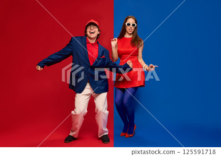 Couple dancing playfully in bold red blue setup Couple dancing playfully in bold red blue setup 125591718