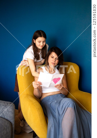 Children girl congratulating mom and giving postcard for mother's day, 8 march, birthday. 125591830