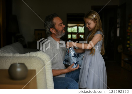 A daughter giving father a christmas gift A daughter giving father a christmas gift 125592553