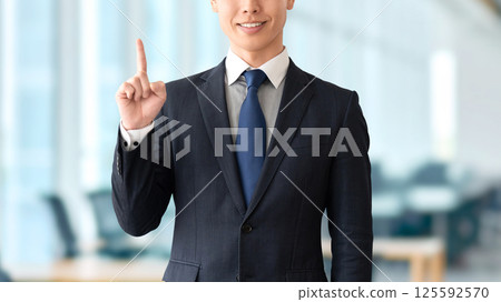 A male businessman pointing his index finger to guide you A male businessman pointing his index finger to guide you 125592570