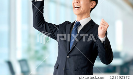 一位微笑的男性商人對拳頭泵感到滿意 一位微笑的男性商人對拳頭泵感到滿意 125592572
