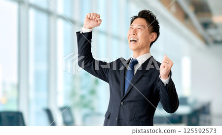 一位微笑的男性商人對拳頭泵感到滿意 125592573