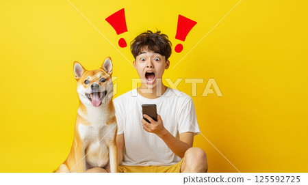 一個男孩和一隻柴犬對他的智慧型手機感到驚訝 125592725