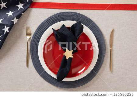 Table setting for USA Independence Day. Festive dinner with red plate and decoration in USA national flag colors white, red and blue. View from above. Copy space. Close up. Table setting for USA Independence Day. Festive dinner with red plate and decoration in USA national flag colors white, red and blue. View from above. Copy space. Close up. 125593225