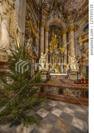 Christmas tree standing in richly decorated baroque church interior in Prague Christmas tree standing in richly decorated baroque church interior in Prague 125593516