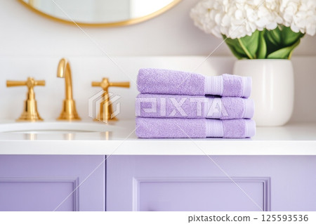 Stylish bathroom vanity with purple towels and elegant decor for a serene atmosphere 125593536