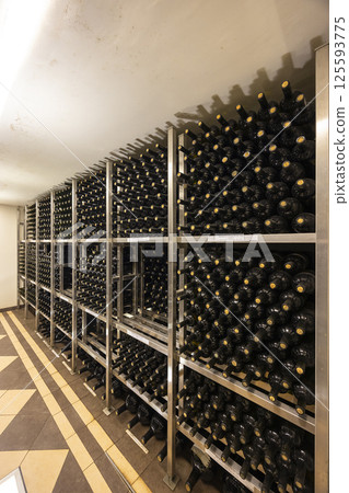 Wine bottles aging on metal racks in cellar of winery or restaurant, Styria, Austria 125593775