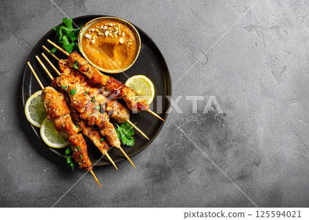 Grilled Chicken satay skewers and peanut spicy sauce 125594021