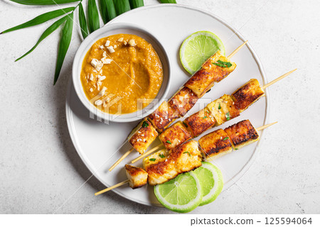Grilled tofu satay skewers and peanut spicy sauce Grilled tofu satay skewers and peanut spicy sauce 125594064