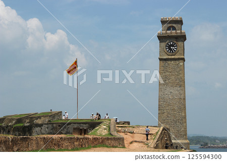 Galle Clock Tower and Flag with Visitors Relaxing Nearby, Galle, Sri Lanka Galle Clock Tower and Flag with Visitors Relaxing Nearby, Galle, Sri Lanka 125594300