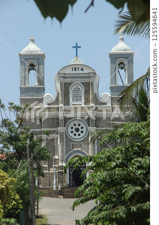 Historic Stone Church with Twin Bell Towers Under Blue Sky in Galle, Sri Lanka 125594641