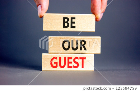 Be our guest symbol. Concept words Be our guest on beautiful wooden block. Businessman's hand. Beautiful grey background. Business and be our guest concept. Copy space. 125594759