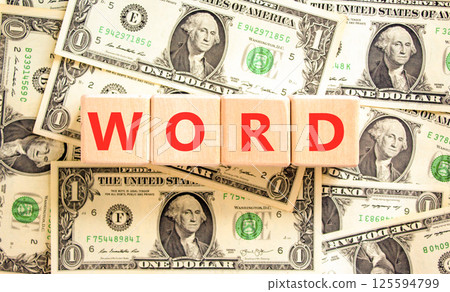 Word symbol. Concept word Word on beautiful wooden blocks. Dollar bills. Beautiful background from dollar bills. Business, lifestyle, support and word concept. Copy space. Word symbol. Concept word Word on beautiful wooden blocks. Dollar bills. Beautiful background from dollar bills. Business, lifestyle, support and word concept. Copy space. 125594799