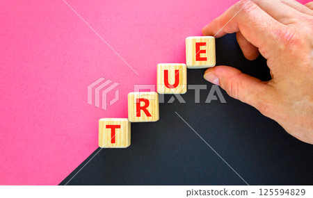 True symbol. Concept word True on beautiful wooden blocks. Businessman hand. Beautiful black and purple background. Business, lifestyle, support and true concept. Copy space. True symbol. Concept word True on beautiful wooden blocks. Businessman hand. Beautiful black and purple background. Business, lifestyle, support and true concept. Copy space. 125594829