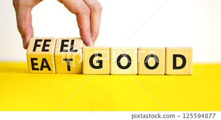 Eat and feel good symbol. Concept words Eat good Feel good on wooden cubes. Beautiful yellow table white background. Doctor hand. Healthy lifestyle eat and feel good concept. Copy space. 125594877
