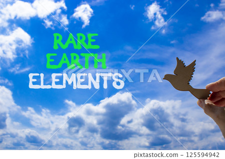 Rare earth elements symbol. Concept words Rare earth elements. Beautiful blue sky clouds background. Businessman hand, wooden birds. Business and rare earth elements concept. Copy space. 125594942