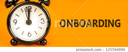 Onboarding success symbol. Concept word Onboarding on beautiful orange paper. Beautiful orange paper background. Black alarm clock. Business onboarding success concept. Copy space. 125594999
