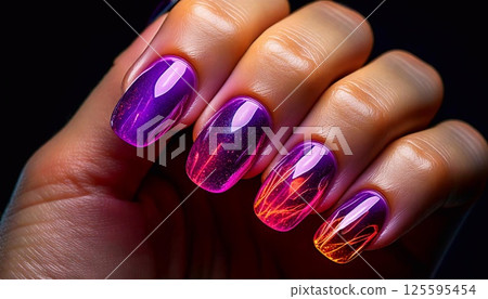A vibrant manicure features purple and orange ombre with sparkles on shiny nails 125595454