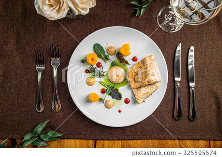 Portion of gourmet fish dish with fruit slices Portion of gourmet fish dish with fruit slices 125595574