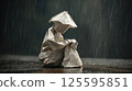 Paper figure of a man sitting on the pavement in the rain, the concept of loneliness 125595851