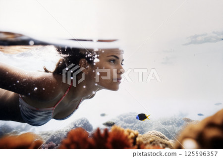Swimmer Exploring Coral Reefs While Observing Colorful Fish in Clear Tropical Waters 125596357