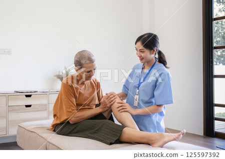 Young Nurse Providing Health Care Advice to Elderly Woman in a Comfortable Home Setting 125597392