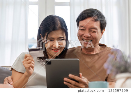 Elderly Couple Collaborating on Family Financial Planning with Digital Tools at Home 125597399