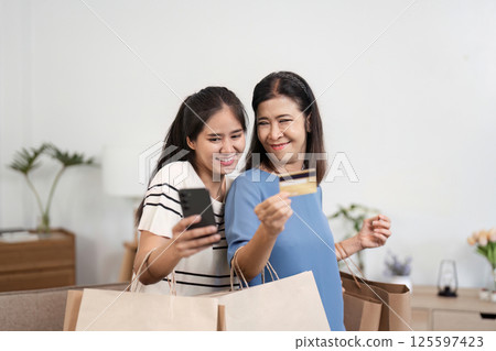 Joyful Mother and Child Enjoying a Shopping Day with Paper Bags in a Modern Home Environment 125597423