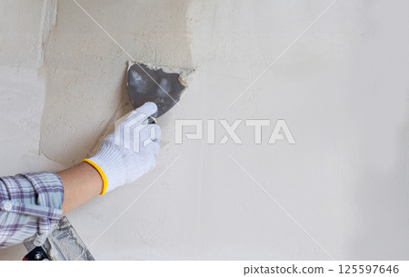 Puttying the wall of the house. 125597646