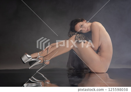 Elegant woman embraces beauty with snake in a captivating artistic setting 125598038