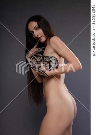 Captivating woman with snake poses in elegant nude display 125598043
