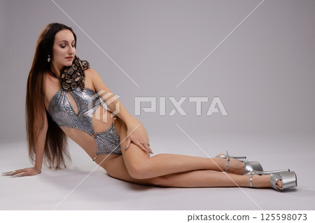 Woman in lingerie poses elegantly with a snake on her shoulder 125598073