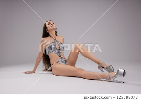 Woman in elegant lingerie with a snake, exuding beauty and grace 125598078