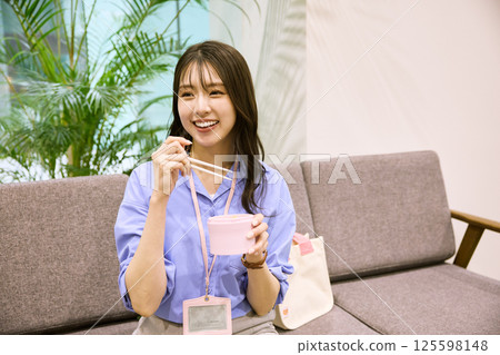 Woman eating lunch in the office Woman eating lunch in the office 125598148