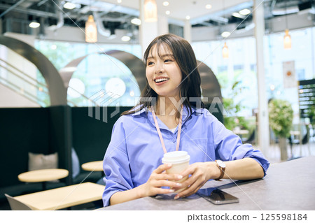 A woman taking a break in the pantry of a shared office 125598184