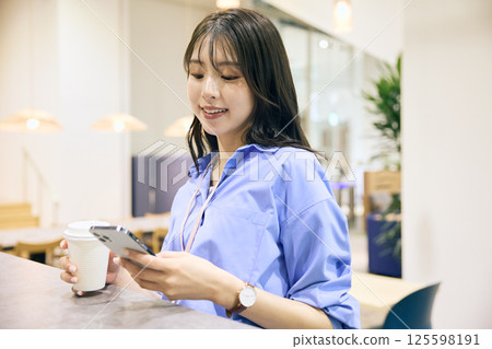 A woman taking a break in the pantry of a shared office A woman taking a break in the pantry of a shared office 125598191
