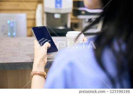 A woman taking a break in the pantry of a shared office A woman taking a break in the pantry of a shared office 125598198