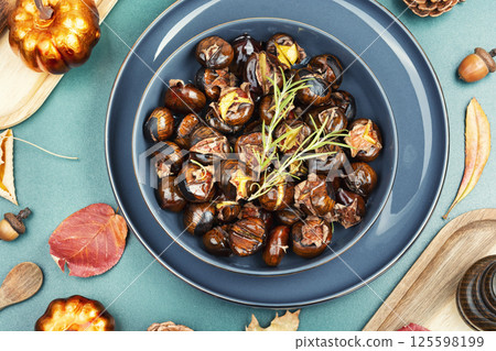 Warm roasted chestnuts served on a plate 125598199