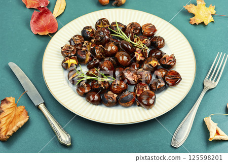 roasted chestnuts served on a plate roasted chestnuts served on a plate 125598201