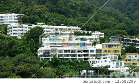 Colorful residential buildings nestled in lush green mountainside 125598299