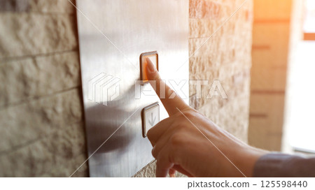 Businesswoman pressing elevator button in hotel 125598440