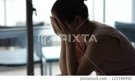 Sad woman crying covering face with hands at hotel 125598492