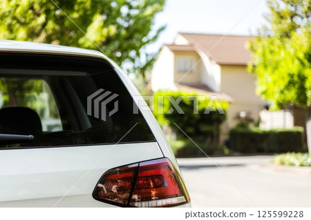 Rear window of a white car parked on the street in residential area. Mockup for the car decals 125599228