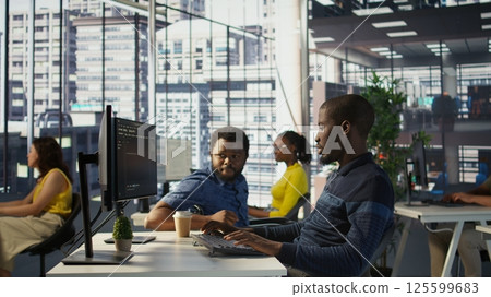 Happy coworker in wheelchair bumping fists with programmer testing machine learning technology. Person with disability saluting colleague in inclusive office, doing friendly gesture, camera B Happy coworker in wheelchair bumping fists with programmer testing machine learning technology. Person with disability saluting colleague in inclusive office, doing friendly gesture, camera B 125599683
