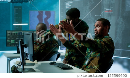 Government analysts work in an advanced command center with satellite radar systems, overseeing surveillance activities and interpreting real time data. Protecting national interests. Camera A. Government analysts work in an advanced command center with satellite radar systems, overseeing surveillance activities and interpreting real time data. Protecting national interests. Camera A. 125599690