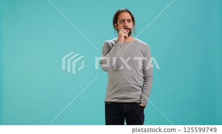 Portrait of man feeling perplexed by confusing information, isolated over studio background. Person scratching head, looking around with puzzled facial expression, camera A 125599749